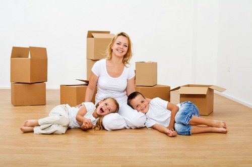 A moving team handling furniture and boxes in a Feltham street