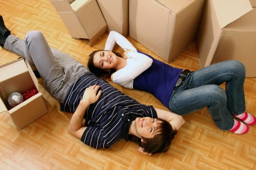 Professional movers carrying furniture from a Feltham home with care